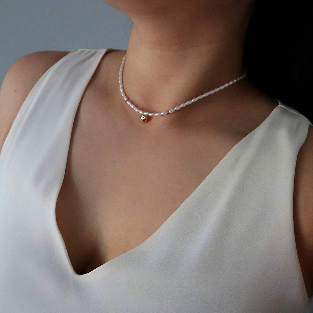 Close view of the gold-plated heart charm against the pearls