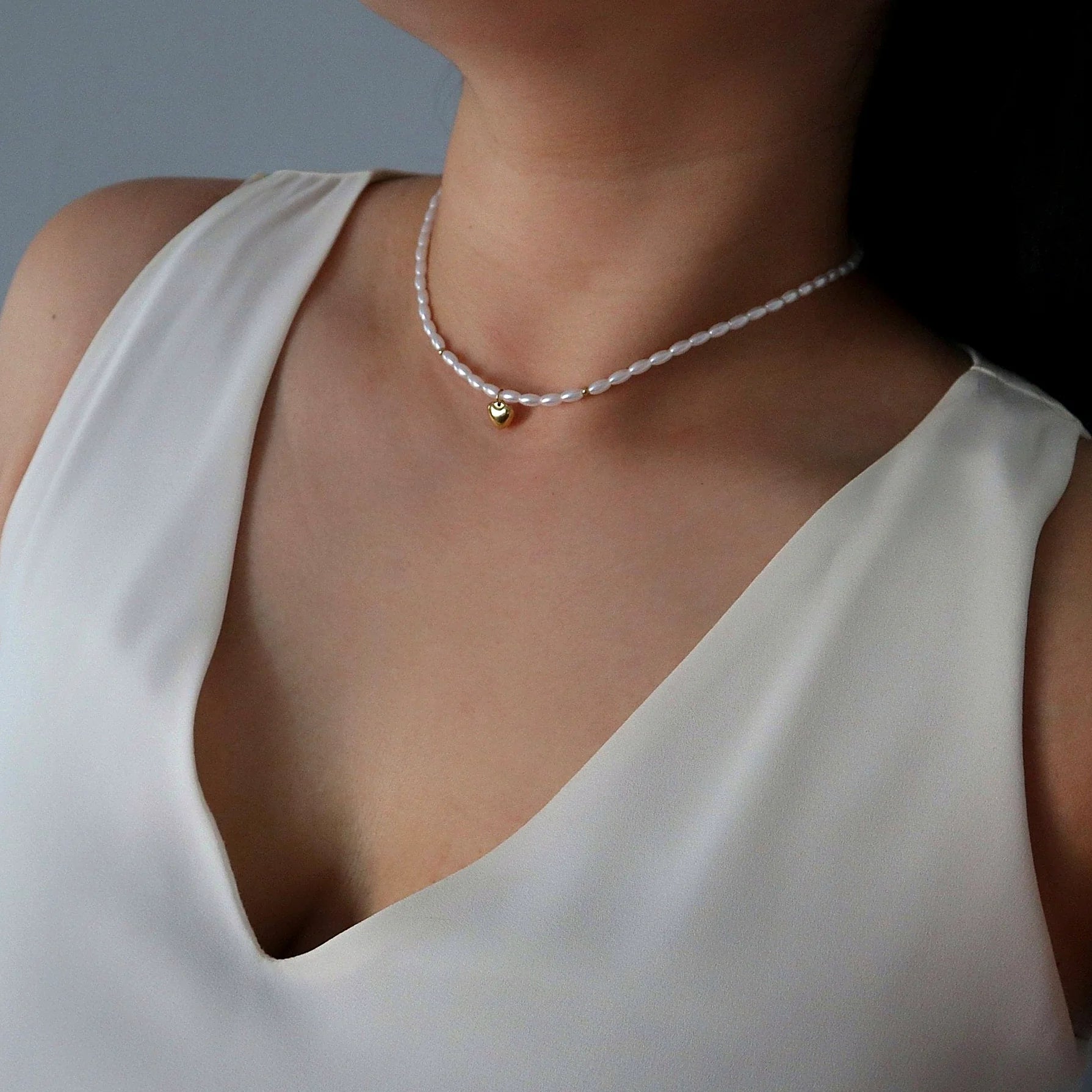 Close view of the gold-plated heart charm against the pearls