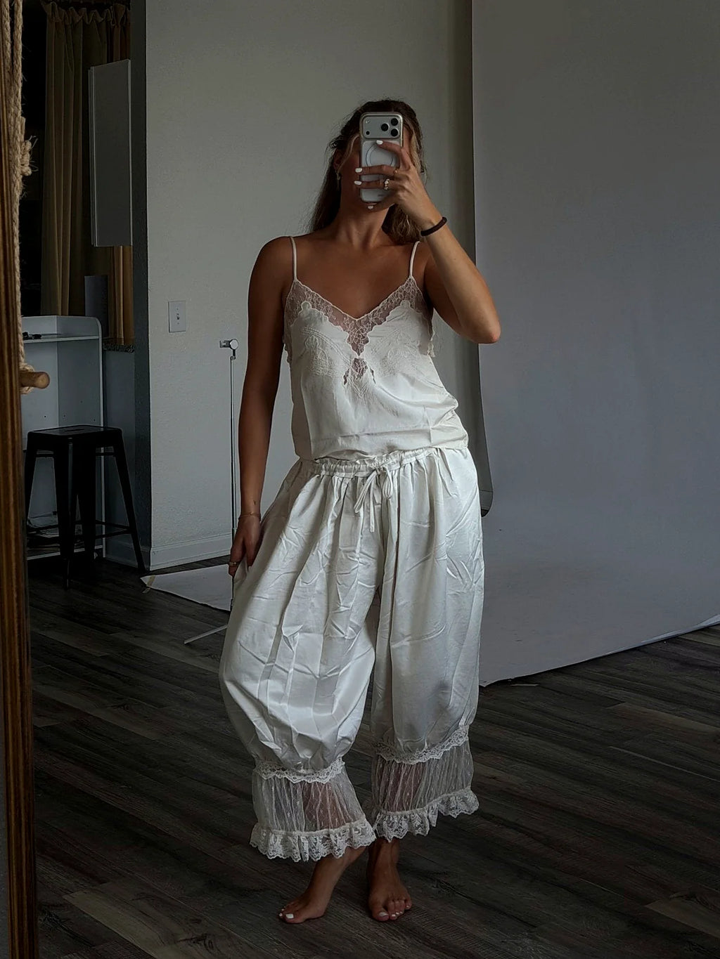 The thin straps of the cream cami top