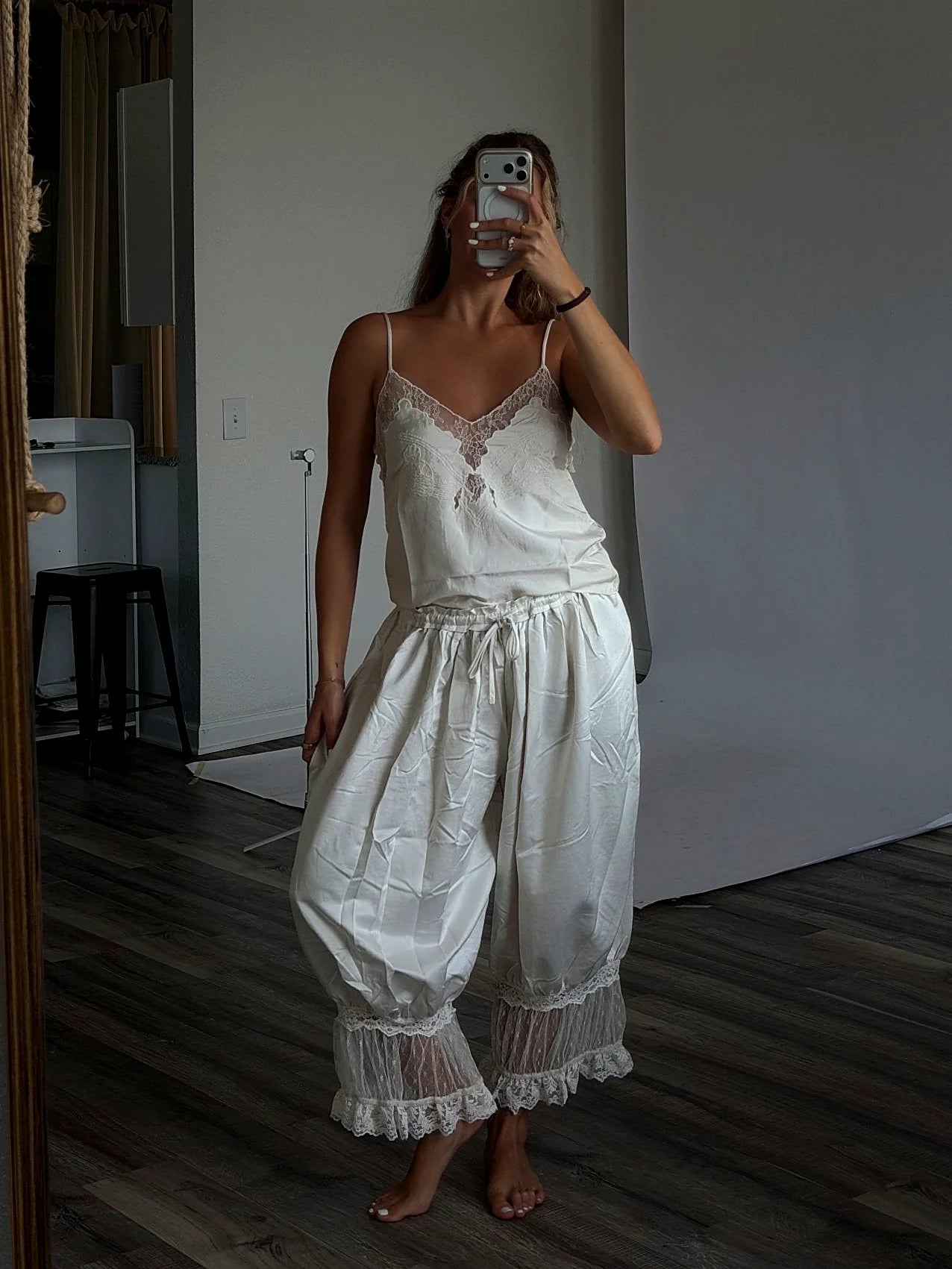 The thin straps of the cream cami top