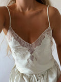 Cream satin cami top with lace detail at the neckline