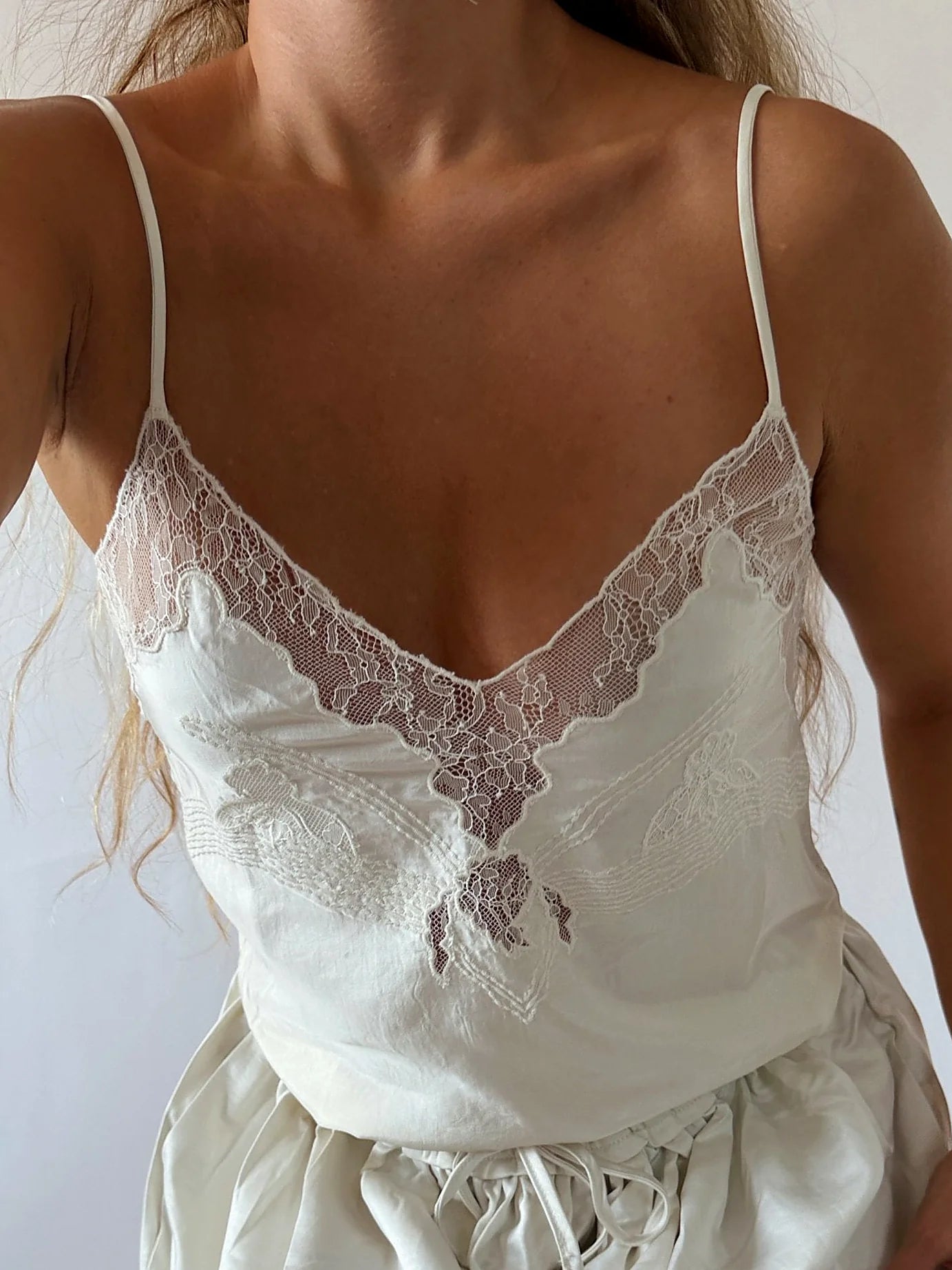 Cream satin cami top with lace detail at the neckline