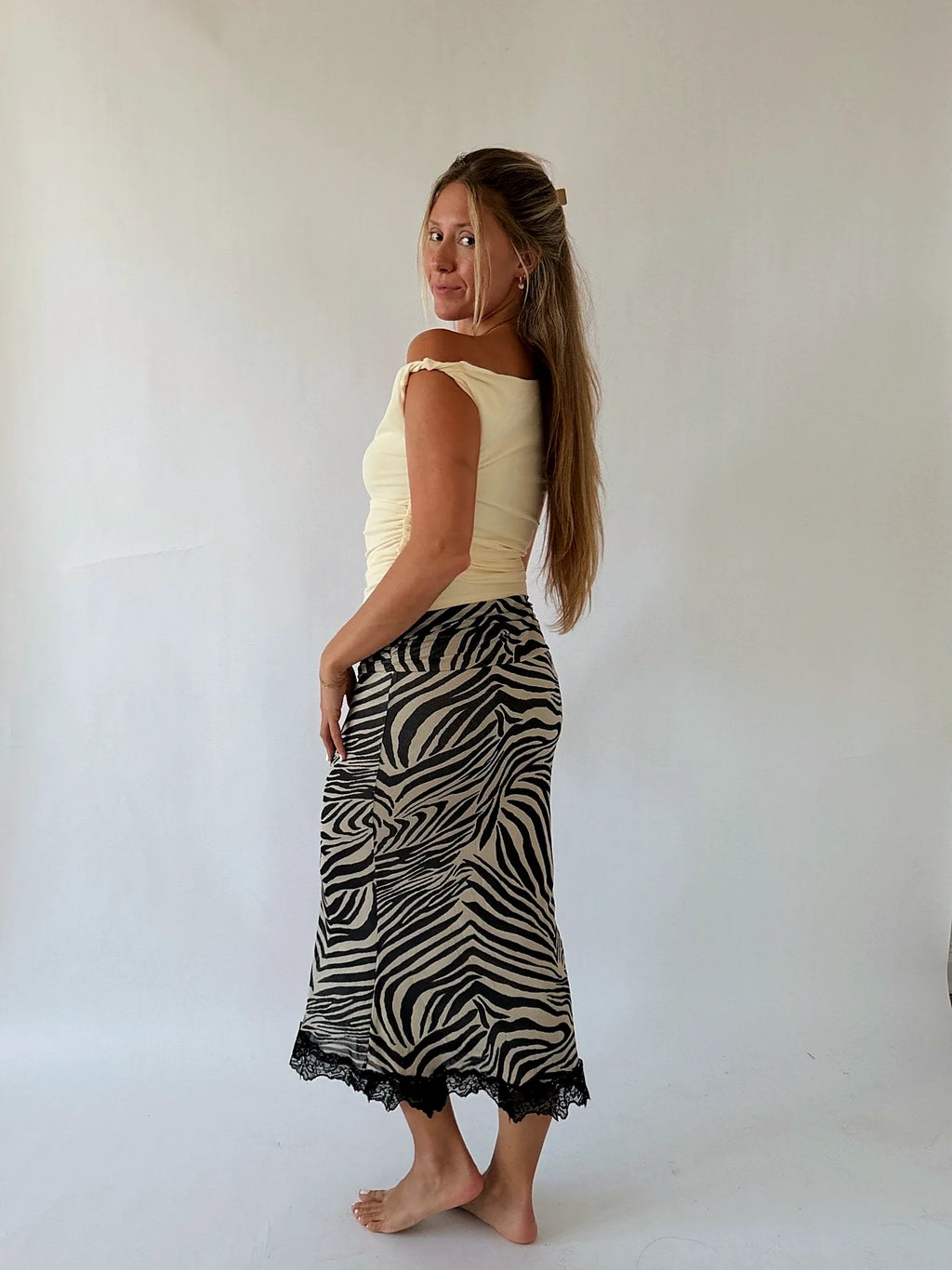 The one-shoulder line of the butter yellow top