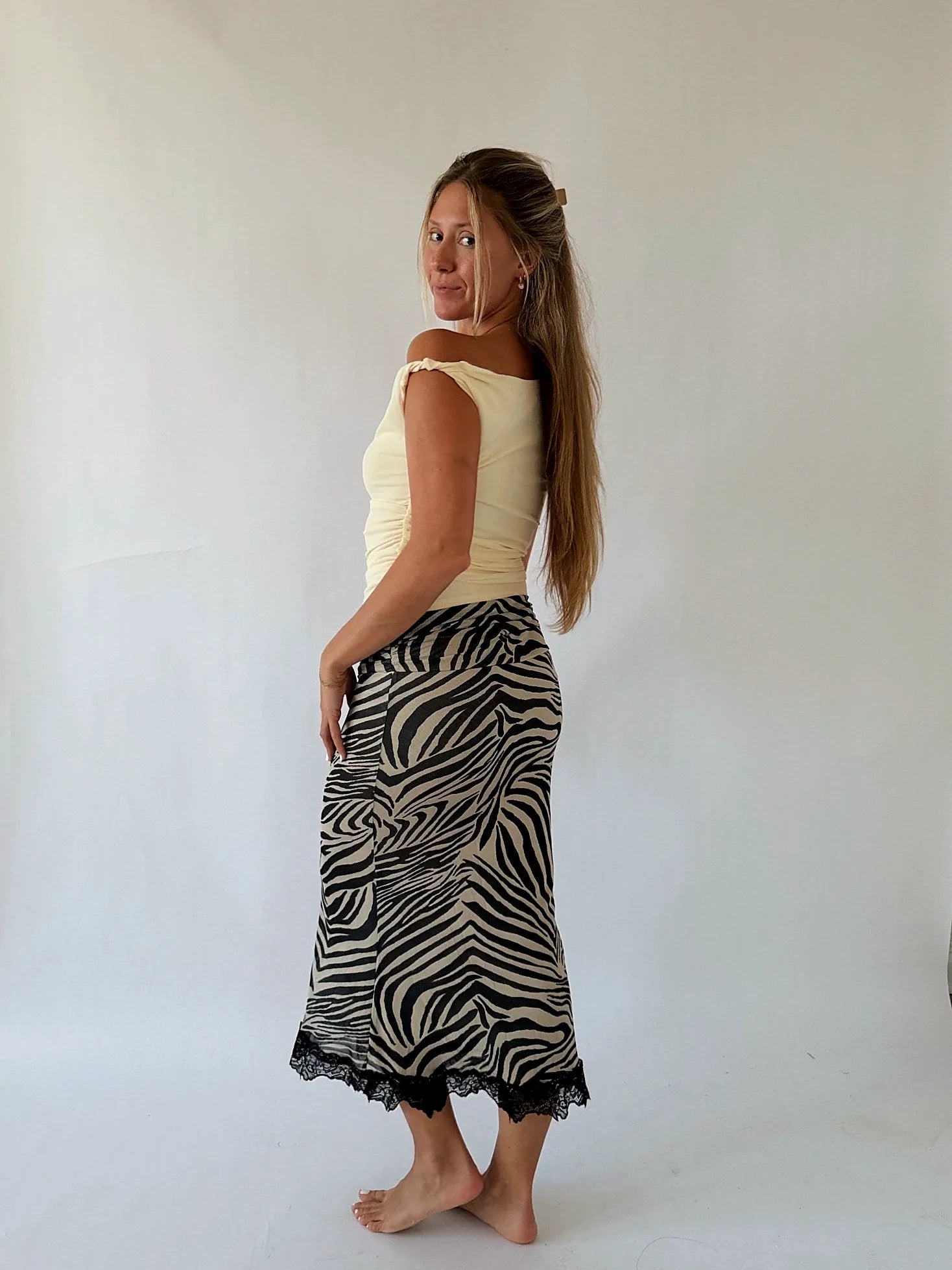 The one-shoulder line of the butter yellow top